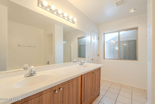 full bathroom featuring a sink, visible vents, double vanity, and tile patterned floors