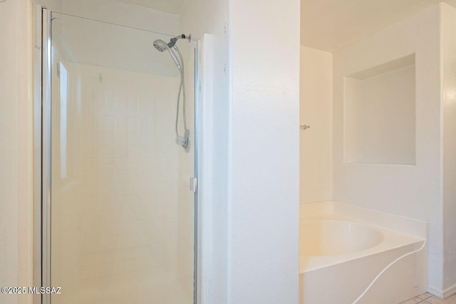 bathroom with a bath and a shower stall