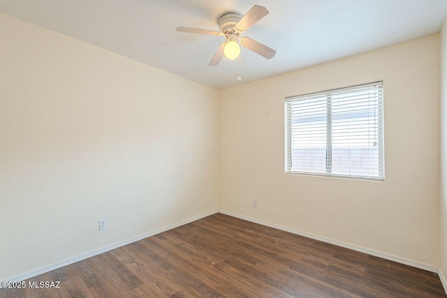 unfurnished room featuring baseboards, dark wood finished floors, and a ceiling fan