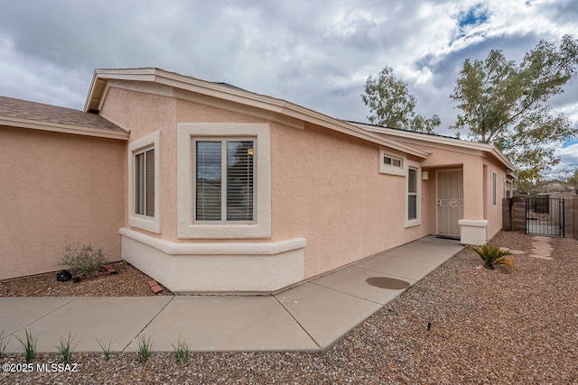 view of home's exterior featuring a gate and stucco siding