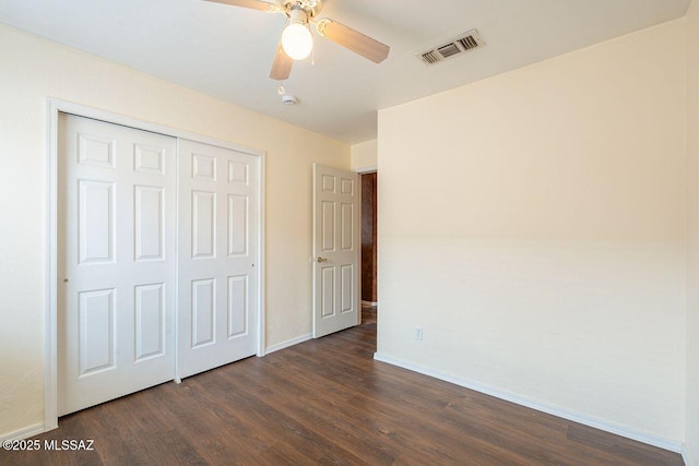 unfurnished bedroom with visible vents, a closet, baseboards, ceiling fan, and dark wood-style flooring