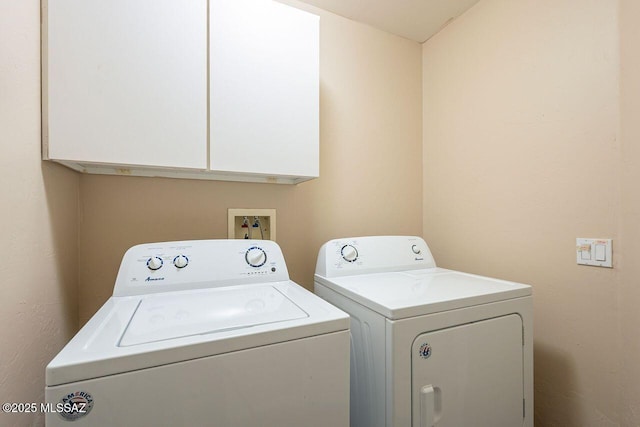 washroom featuring cabinet space and independent washer and dryer