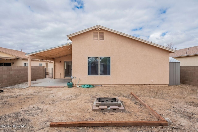 rear view of property with a patio area, a fenced backyard, and stucco siding