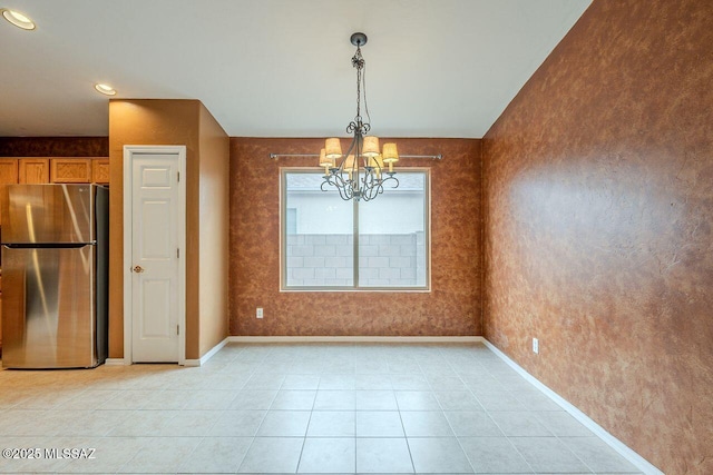 unfurnished dining area featuring a notable chandelier, baseboards, and light tile patterned floors