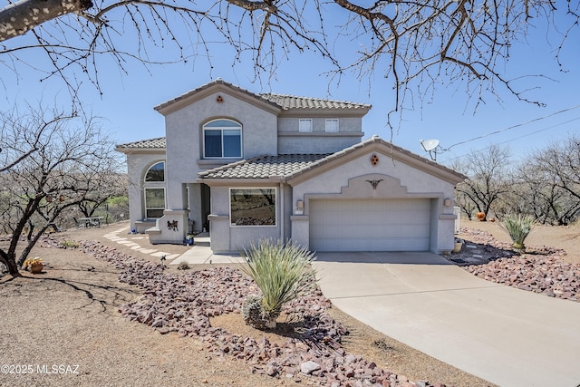 mediterranean / spanish-style house featuring a tile roof, stucco siding, and concrete driveway