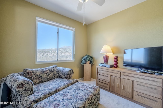 sitting room with light carpet, baseboards, and a ceiling fan