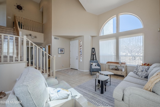 tiled living room featuring a wealth of natural light, stairway, visible vents, and baseboards