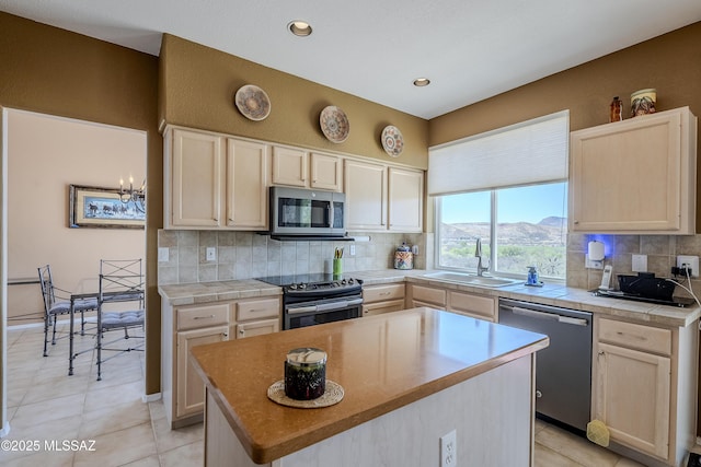 kitchen with recessed lighting, backsplash, a kitchen island, appliances with stainless steel finishes, and a sink