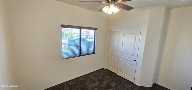 unfurnished bedroom with a closet, a ceiling fan, and stone finish floor