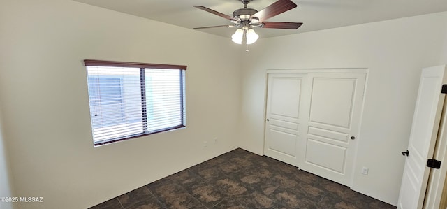 unfurnished bedroom featuring a closet, ceiling fan, and stone finish floor