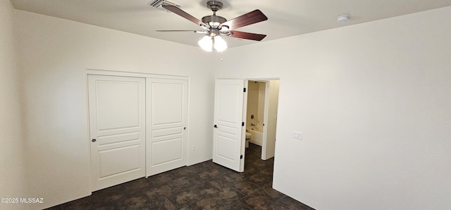 unfurnished bedroom featuring a ceiling fan, a closet, and stone finish flooring