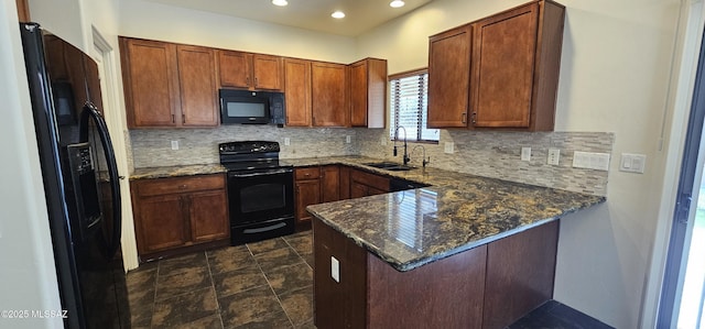 kitchen featuring backsplash, a peninsula, black appliances, and a sink