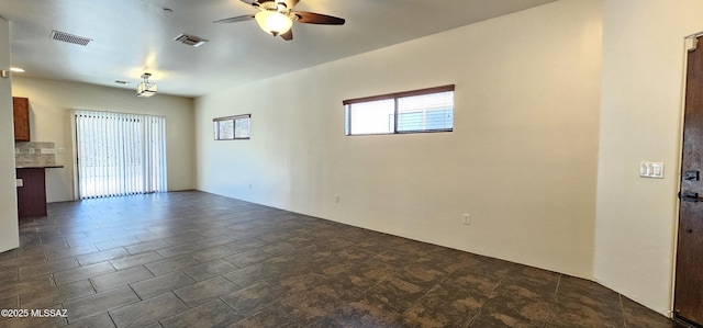 unfurnished room featuring visible vents and ceiling fan