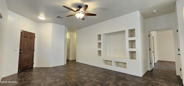 empty room with visible vents, built in shelves, and ceiling fan