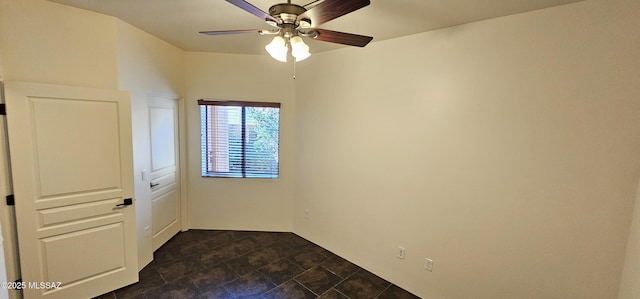 spare room with stone finish floor and ceiling fan
