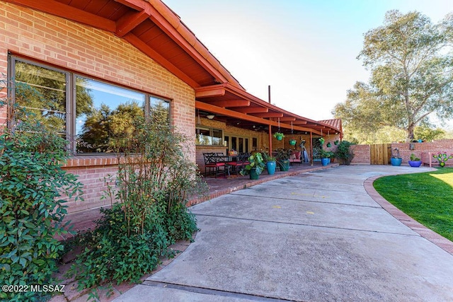 3435 E Via Guadalupe, Tucson, AZ 85716 - view of property exterior featuring brick siding, a patio area, and fence