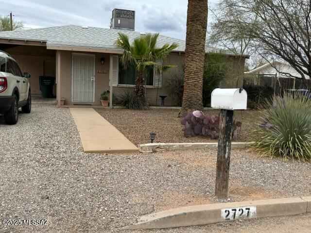 view of front of home featuring a carport and roof with shingles