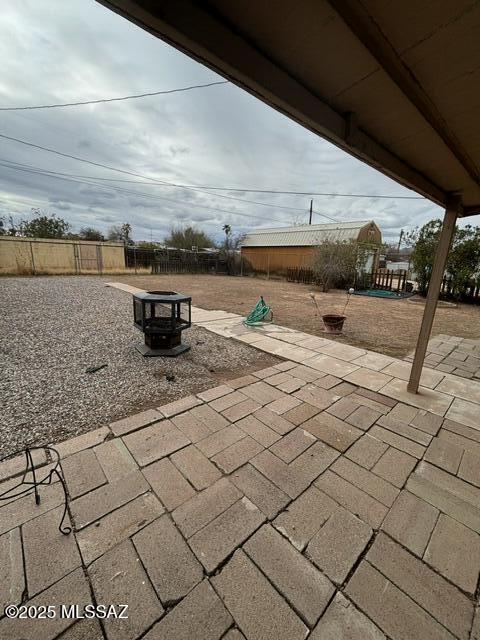 view of patio featuring fence and an outdoor fire pit