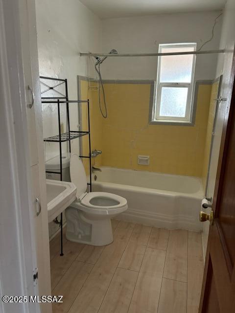 full bathroom with wood finish floors, toilet, and shower / washtub combination