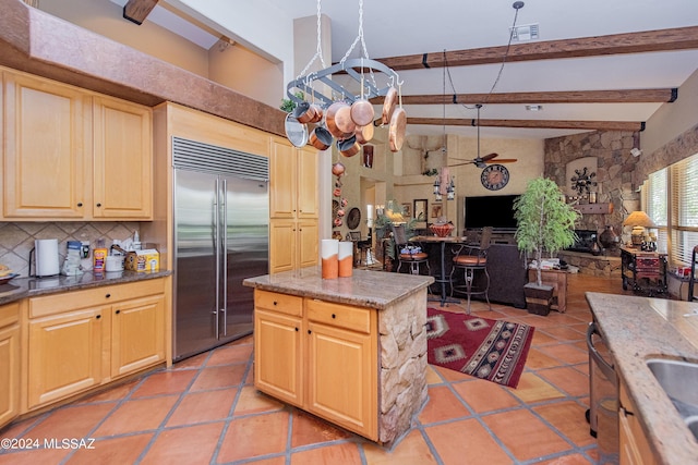 kitchen featuring open floor plan, backsplash, beam ceiling, and stainless steel built in refrigerator