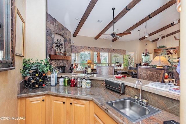 kitchen with visible vents, open floor plan, a fireplace, a ceiling fan, and a sink