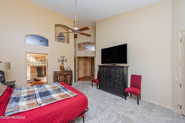 carpeted bedroom featuring ensuite bath, baseboards, and high vaulted ceiling