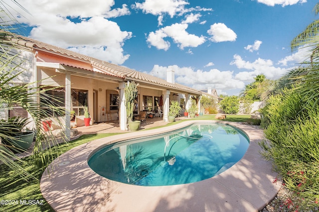 outdoor pool featuring ceiling fan and a patio