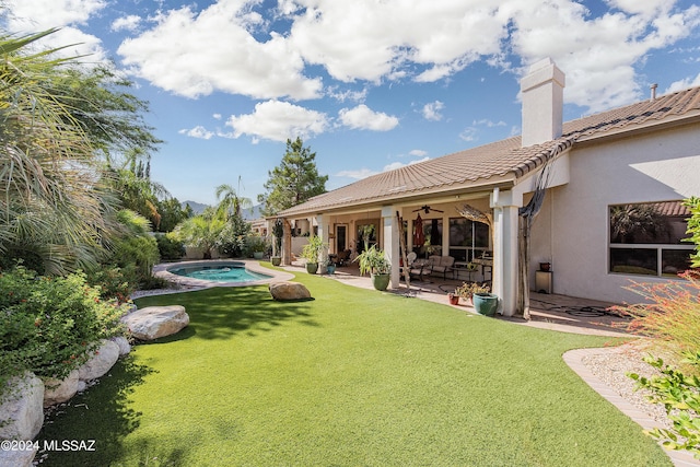 view of yard featuring a ceiling fan, a jacuzzi, and a patio area