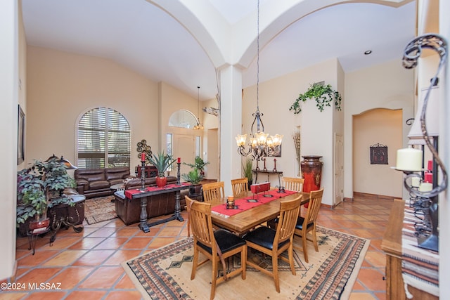 dining room with light tile patterned floors, arched walkways, high vaulted ceiling, and an inviting chandelier