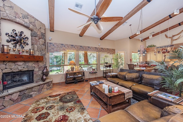 living room with visible vents, beam ceiling, a fireplace, light tile patterned flooring, and a ceiling fan