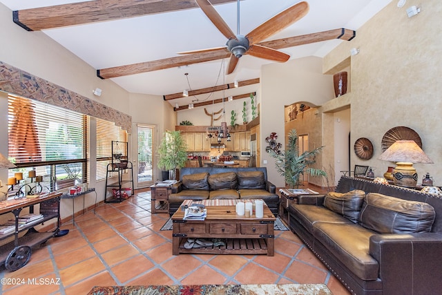 living area with beamed ceiling, light tile patterned flooring, a ceiling fan, and a towering ceiling