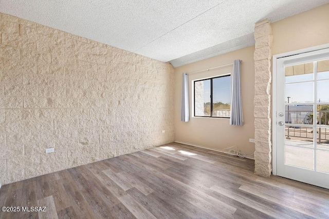 spare room featuring a textured ceiling and wood finished floors