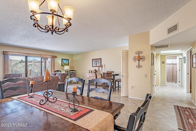 dining space with a chandelier, visible vents, and a textured ceiling