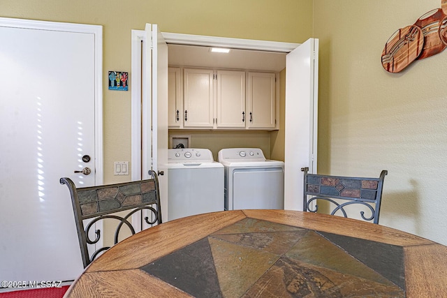 clothes washing area with cabinet space and washer and clothes dryer