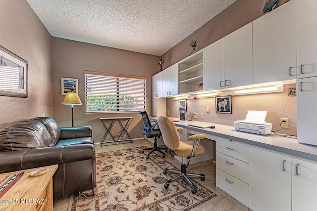 office space featuring a textured wall, a textured ceiling, light tile patterned floors, and built in study area