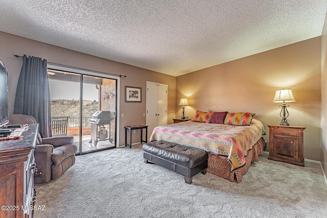 carpeted bedroom with access to outside, baseboards, and a textured ceiling