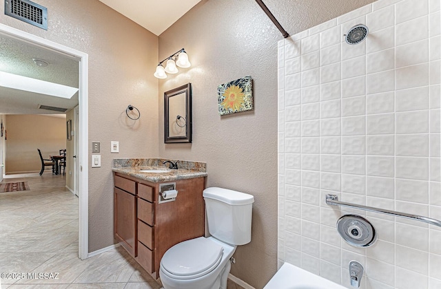 bathroom with visible vents, toilet, shower / tub combination, vanity, and a textured wall