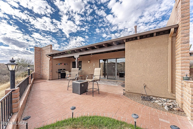 view of patio featuring a grill and an outdoor fire pit