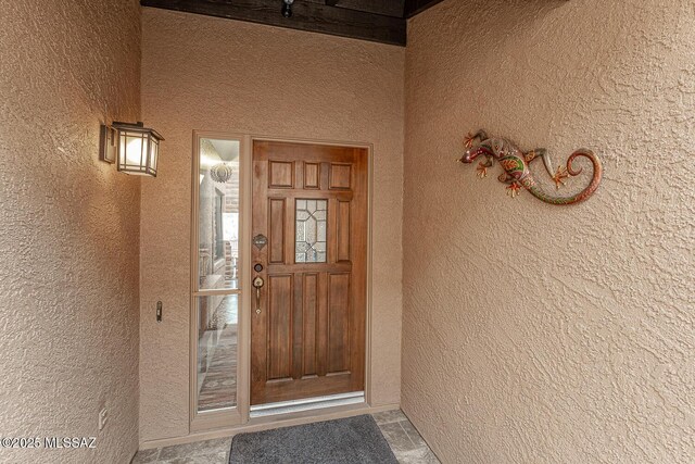 entrance to property featuring stucco siding