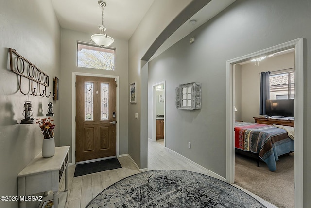 entryway with a towering ceiling, baseboards, and wood tiled floor