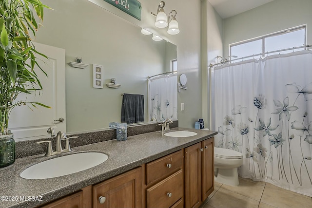full bathroom featuring double vanity, toilet, tile patterned flooring, and a sink