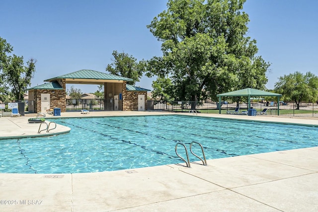 pool featuring a gazebo, fence, and a patio area