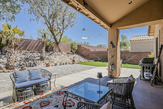 view of patio featuring outdoor dining area, a fenced backyard, and grilling area