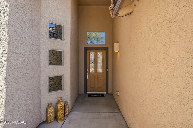 entrance to property featuring stucco siding