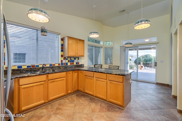 1181 W Placita Lucinda, Green Valley, AZ 85614 - kitchen with visible vents, dark stone countertops, a peninsula, high vaulted ceiling, and a sink