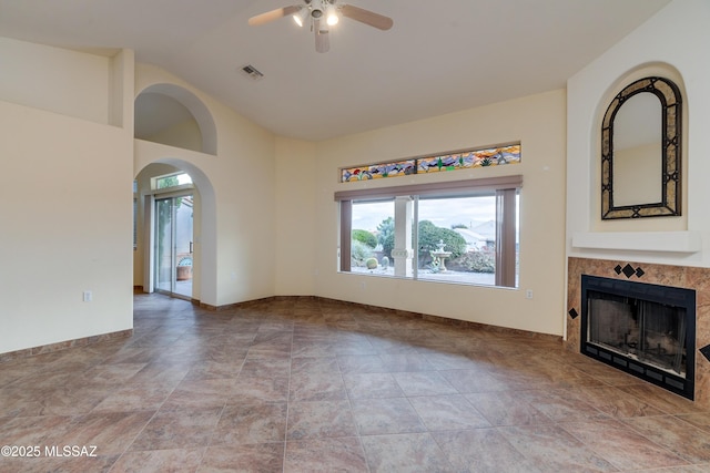 1181 W Placita Lucinda, Green Valley, AZ 85614 - unfurnished living room with visible vents, a ceiling fan, arched walkways, a fireplace, and baseboards
