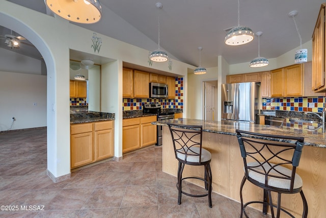 1181 W Placita Lucinda, Green Valley, AZ 85614 - kitchen with lofted ceiling, dark stone countertops, a peninsula, arched walkways, and stainless steel appliances