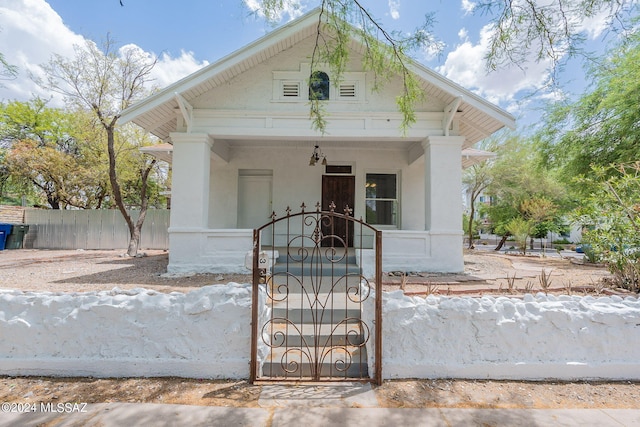 view of front of property with covered porch and fence