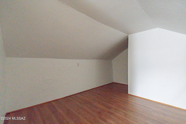 additional living space with vaulted ceiling and wood finished floors