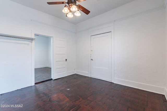 unfurnished bedroom with a ceiling fan, dark wood-style floors, baseboards, and a closet